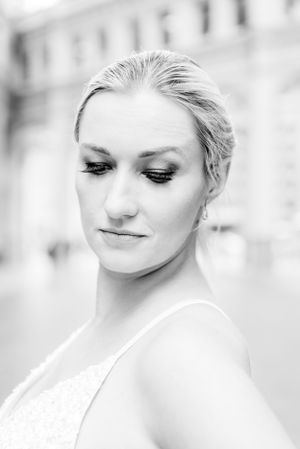 black and white portrait of blonde woman with bun under Wrigley Building