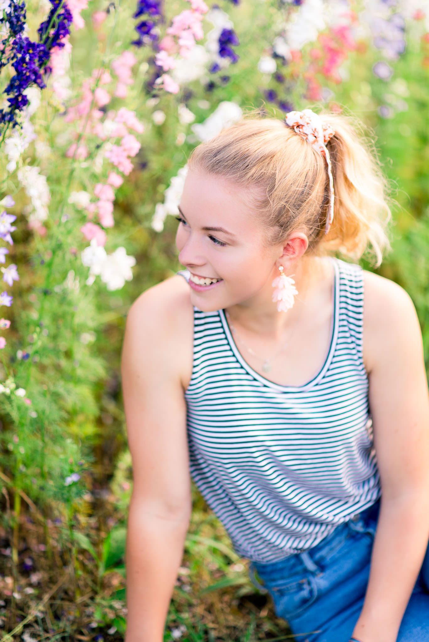 blonde lady looking towards field of pink and purple flowers at the marmalade Lily