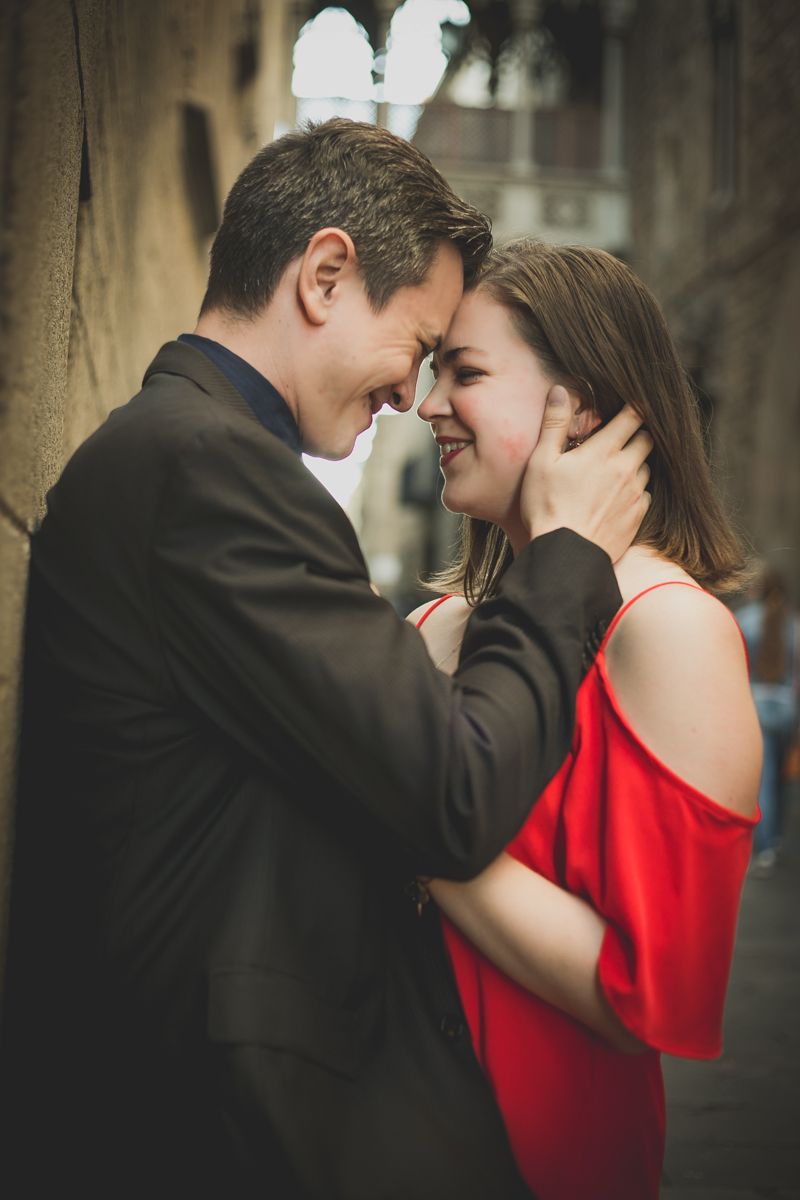 A man caresses his fiancé after their engagement in the Gothic Quarter of Barcelona