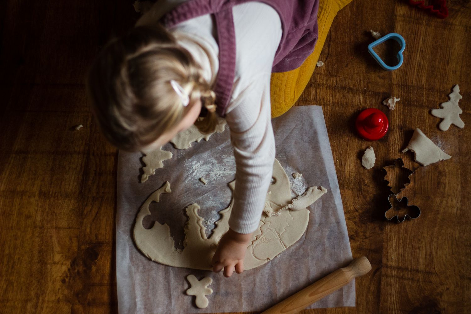 In a house in Havant a toddler sits on the floor cutting out salt dough Christmas ornaments