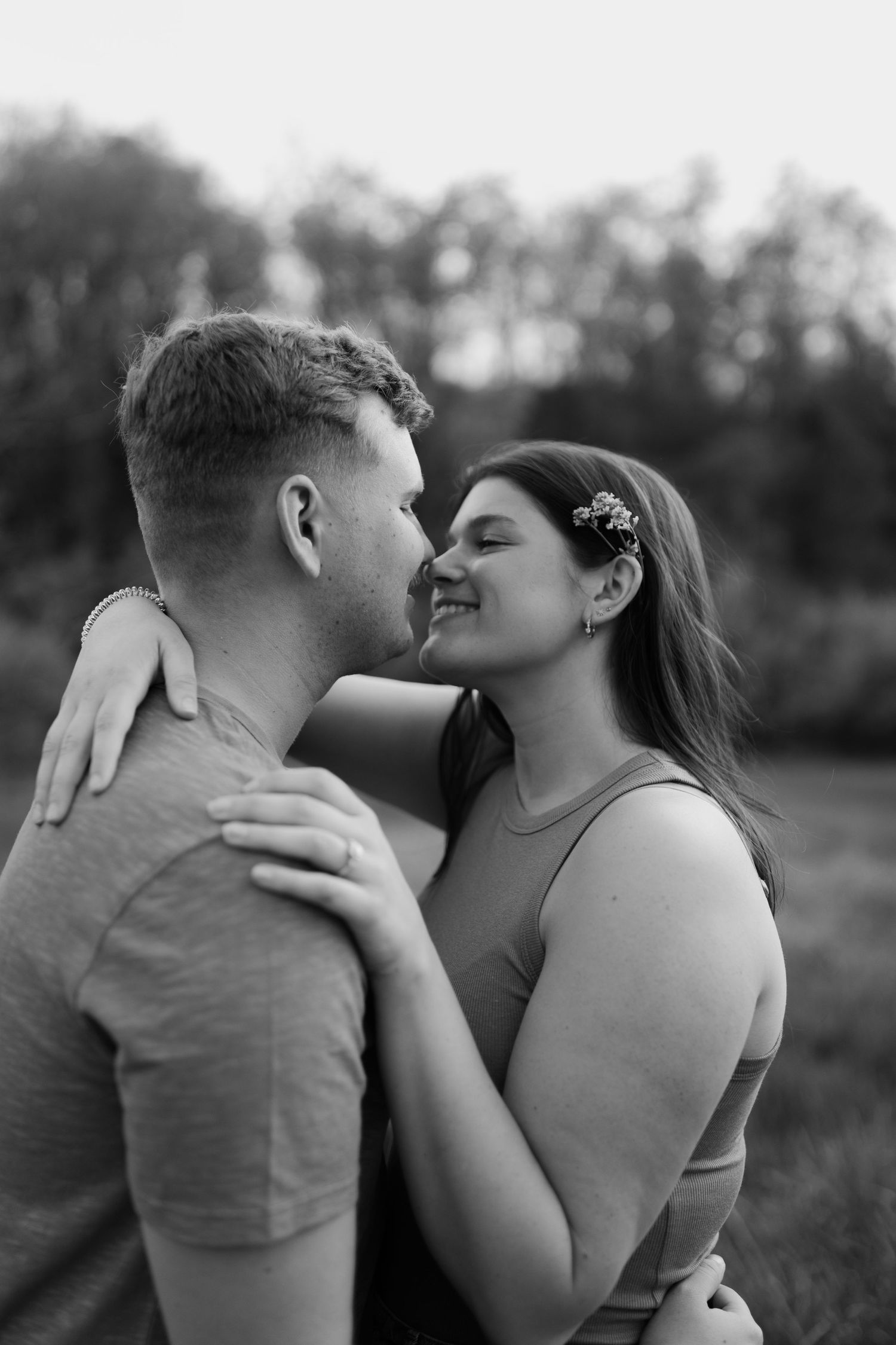 Intimate black and white portrait of couple embracing outdoors.