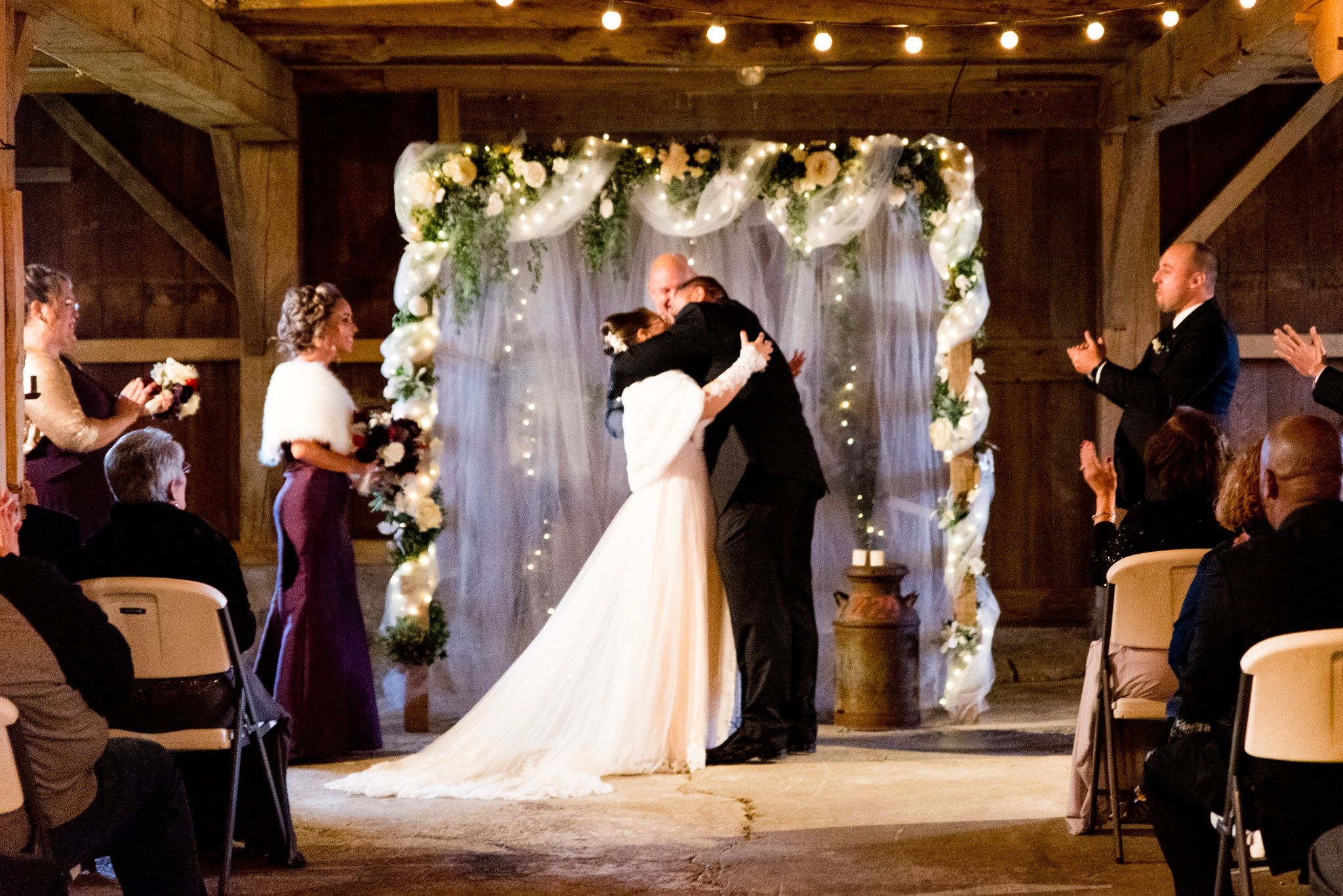 bride and groom hugging and kissing at the alter after bring pronounced husband and wife