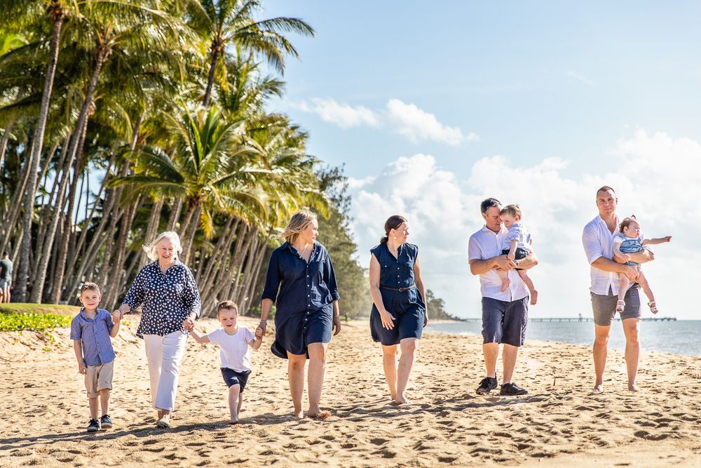 A family walks along the beach at palm cove for family portraits