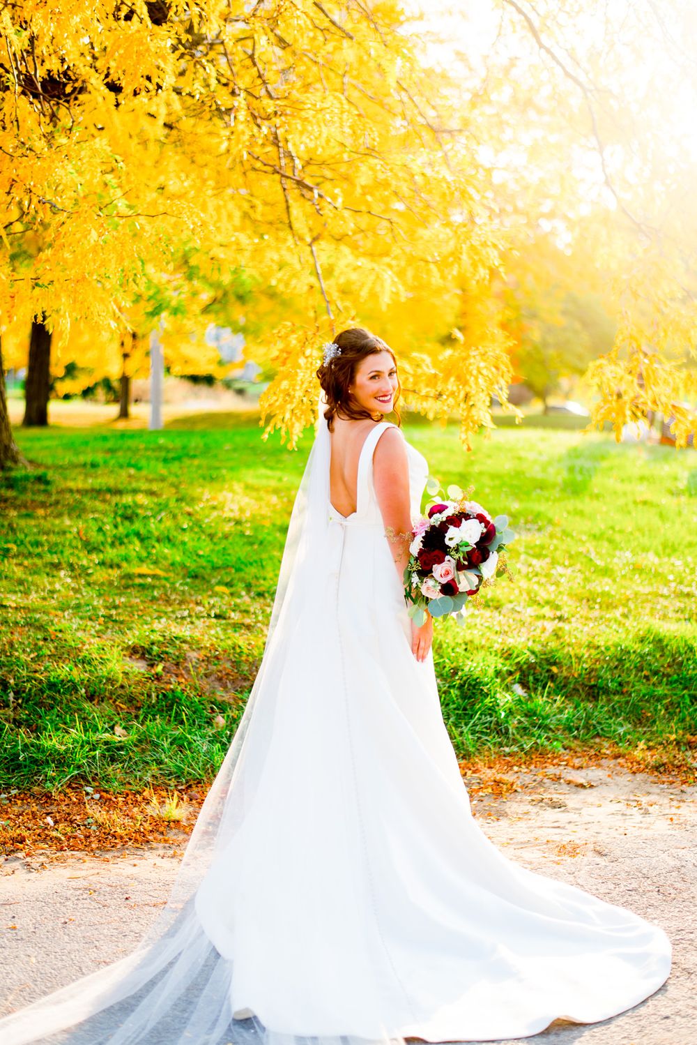 gorgeous chicago bride poses with her bouquet in green park on wedding day