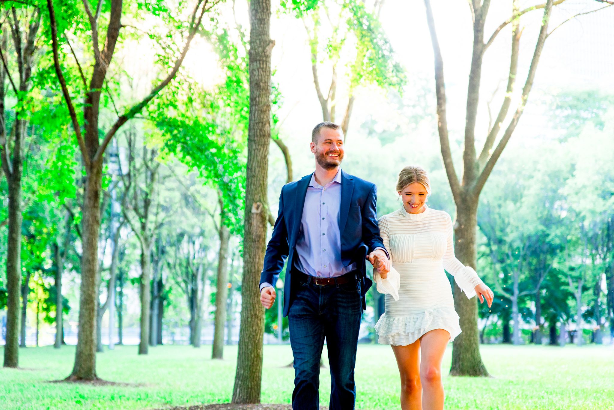 couple running through trees at Millennium Park at sunset