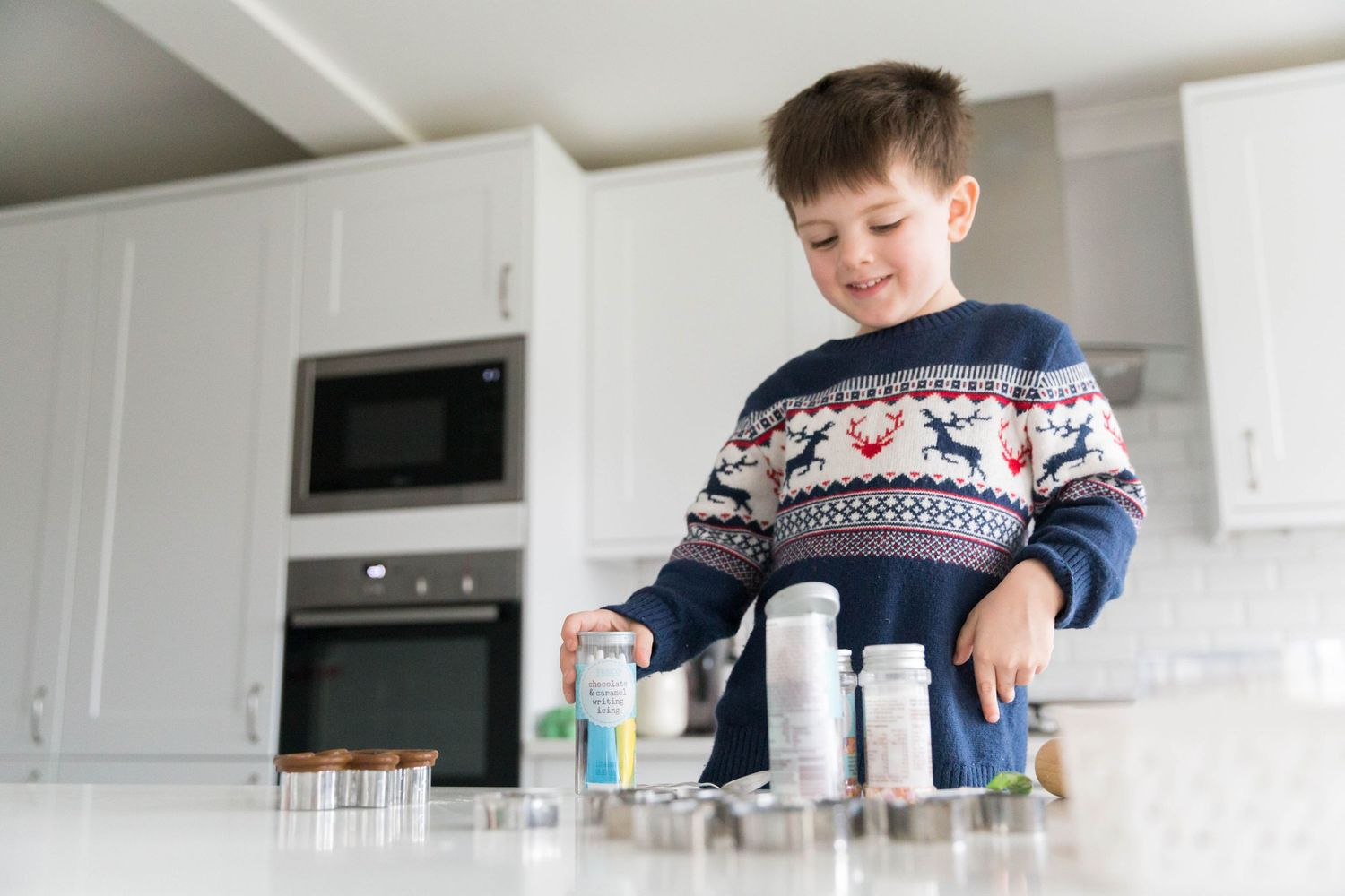 little boy smiling wearing navy Christmas jumper