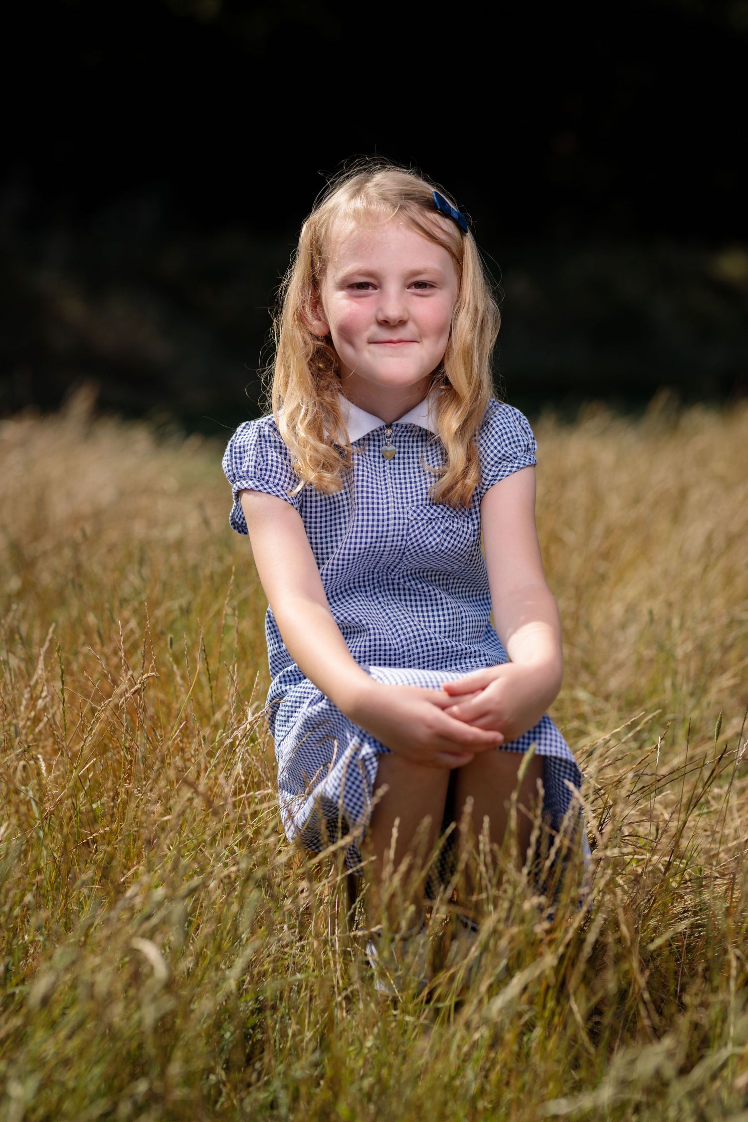 Girl sitting in summer long grass