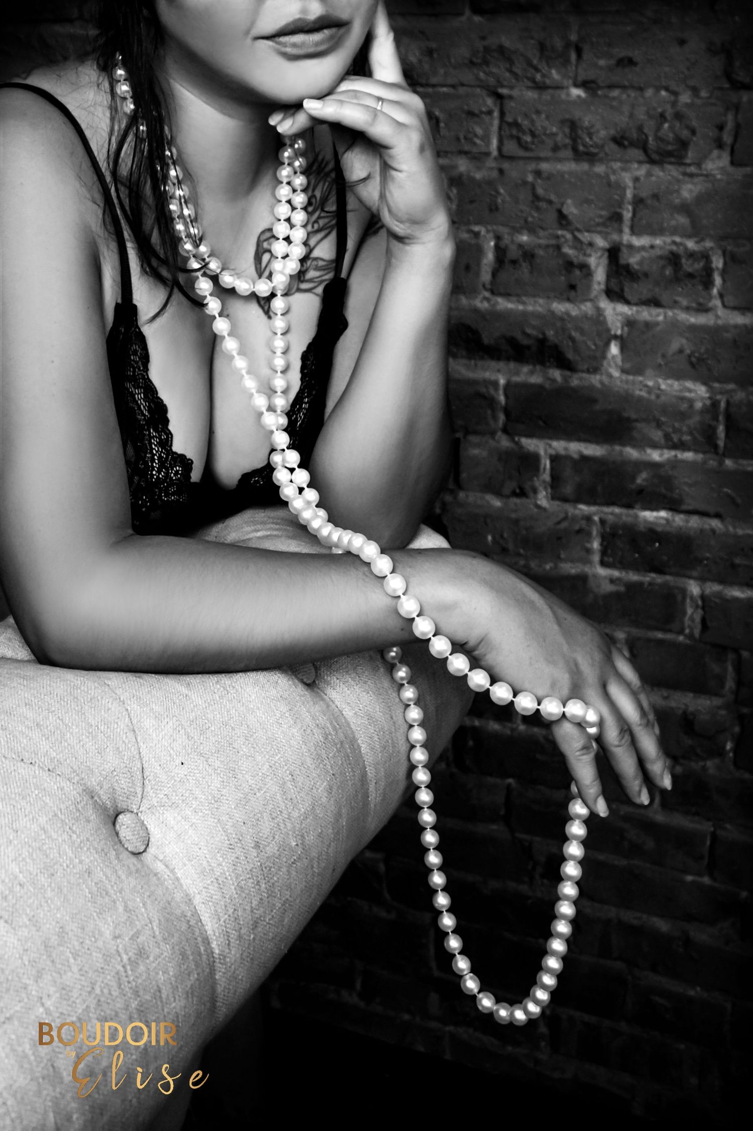 BOUDOIR BY ELISE BEAUTIFUL WOMAN WEARING PEARLS IN BLACK AND WHITE CLOSE UP OF HER LIPS, CLEAVAGE, AND HAND