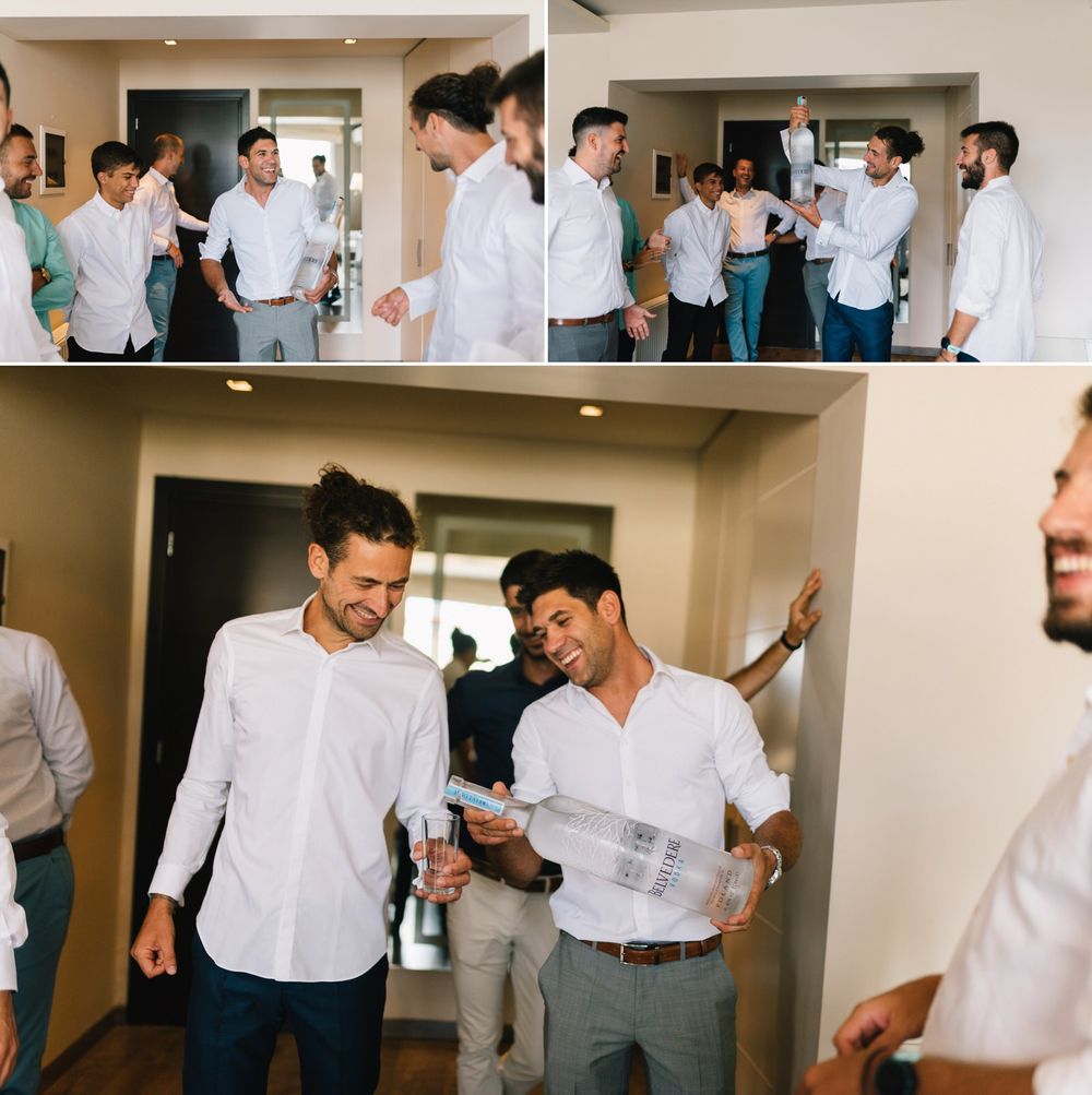 Groomsmen sharing happy moments and laughter while getting dressed for the wedding.