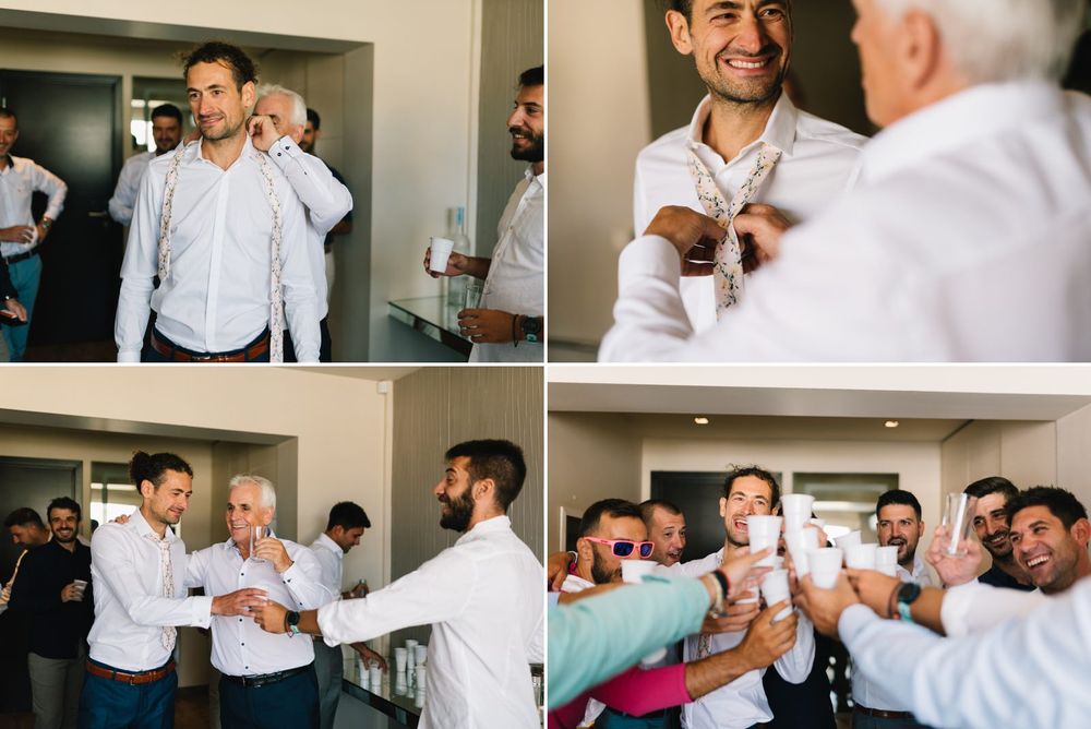 Wedding party members helping each other with final preparations and adjustments.