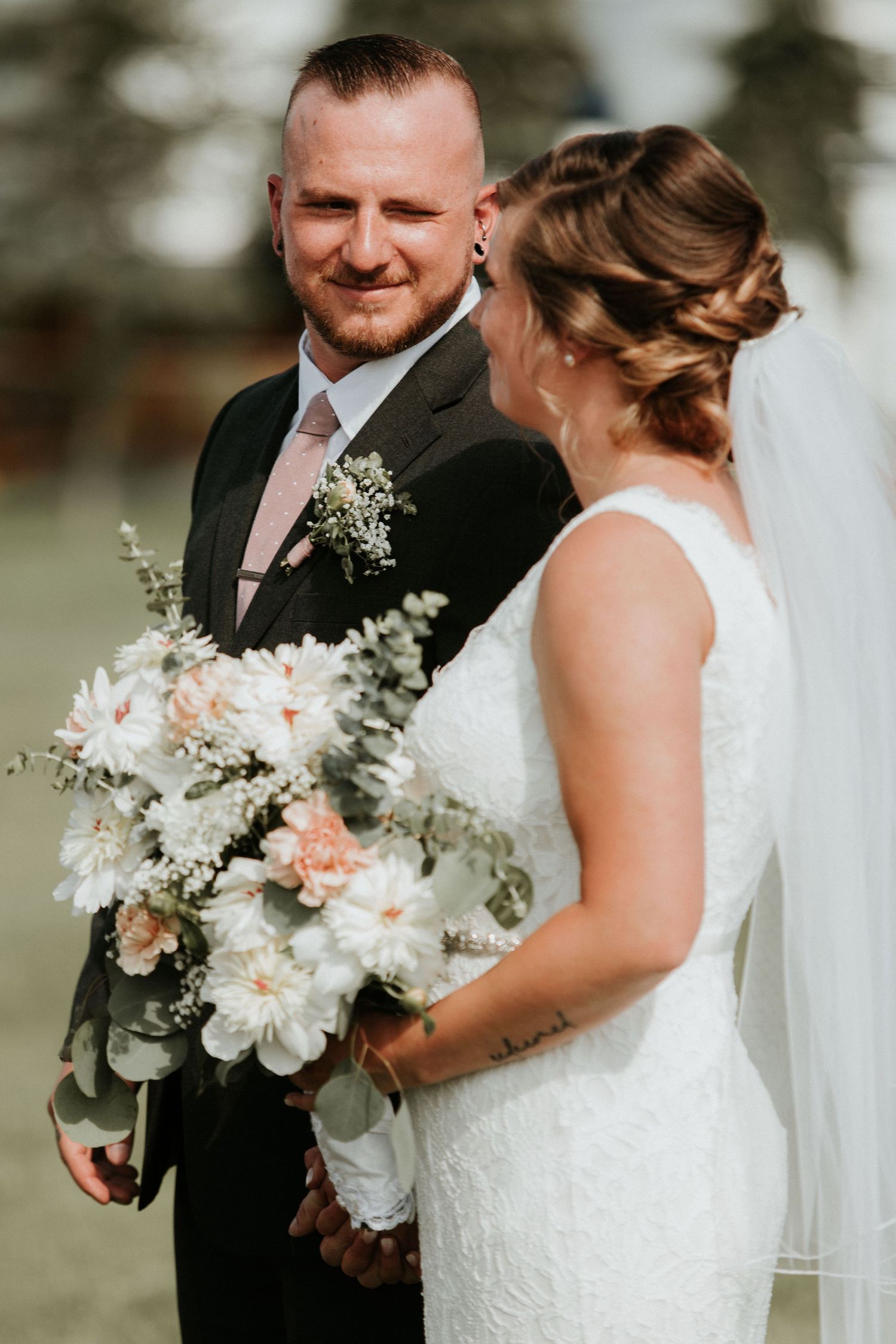 groom smiling at bride at the alter