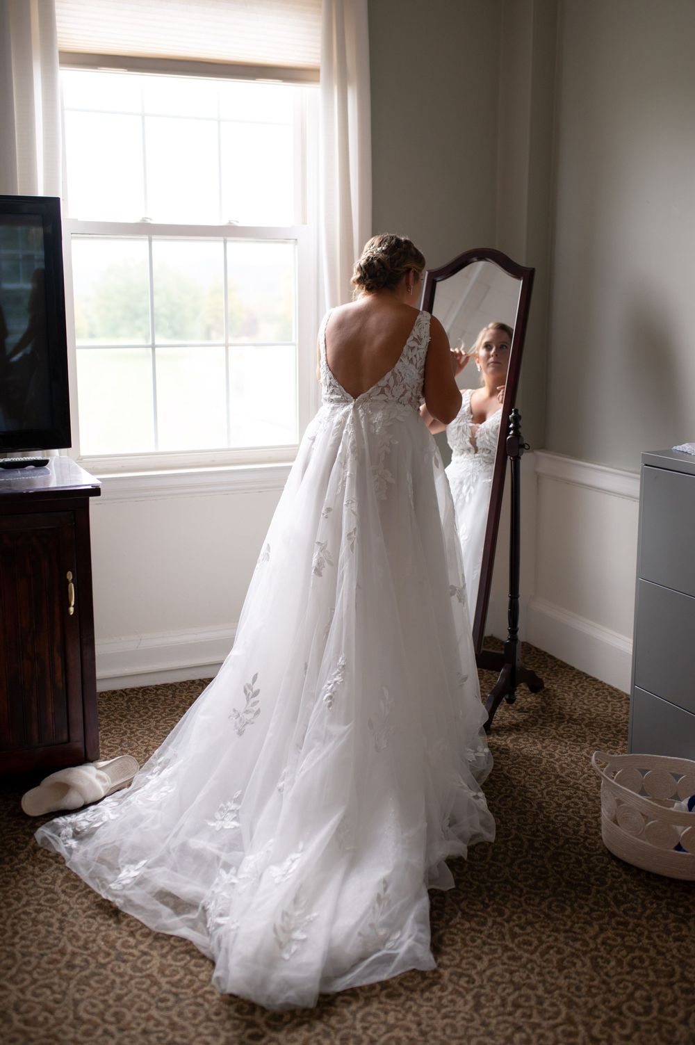 Wedding gown with open back design reflecting in a mirror.