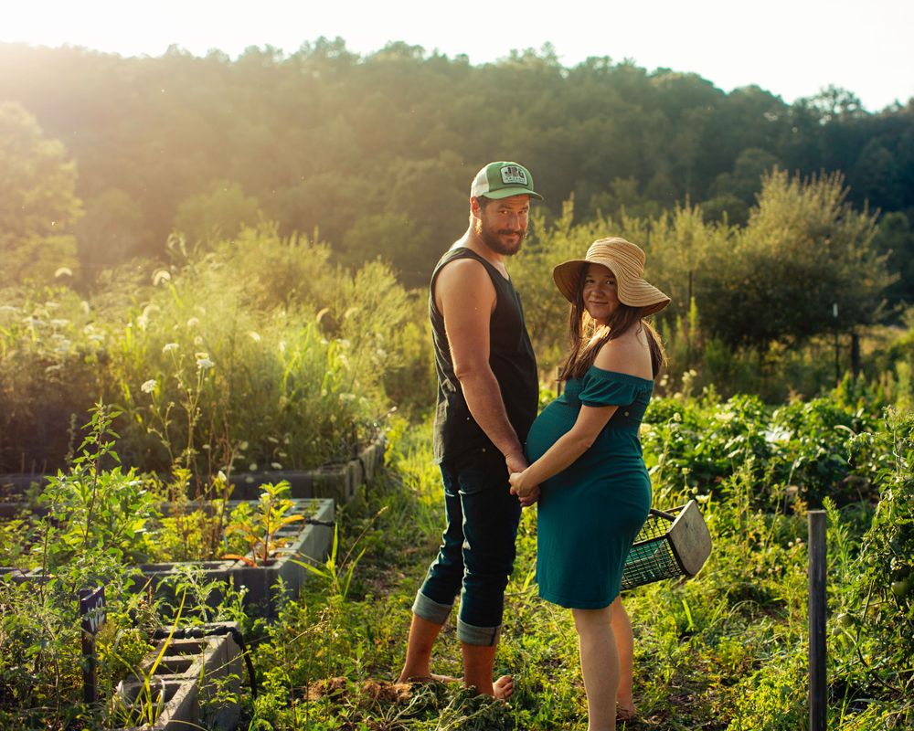 A couple shares an intimate moment in a sunlit garden during golden hour.