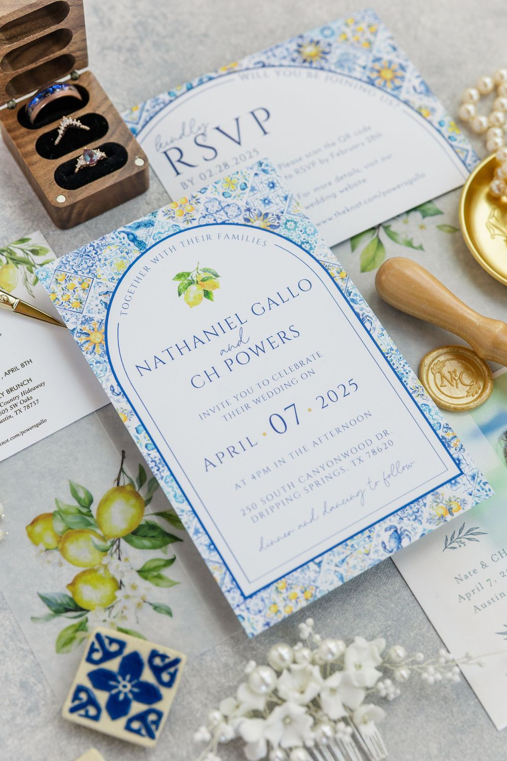 Wedding invitation with blue floral design and lemon motif featuring RSVP card and elegant wax seal details.