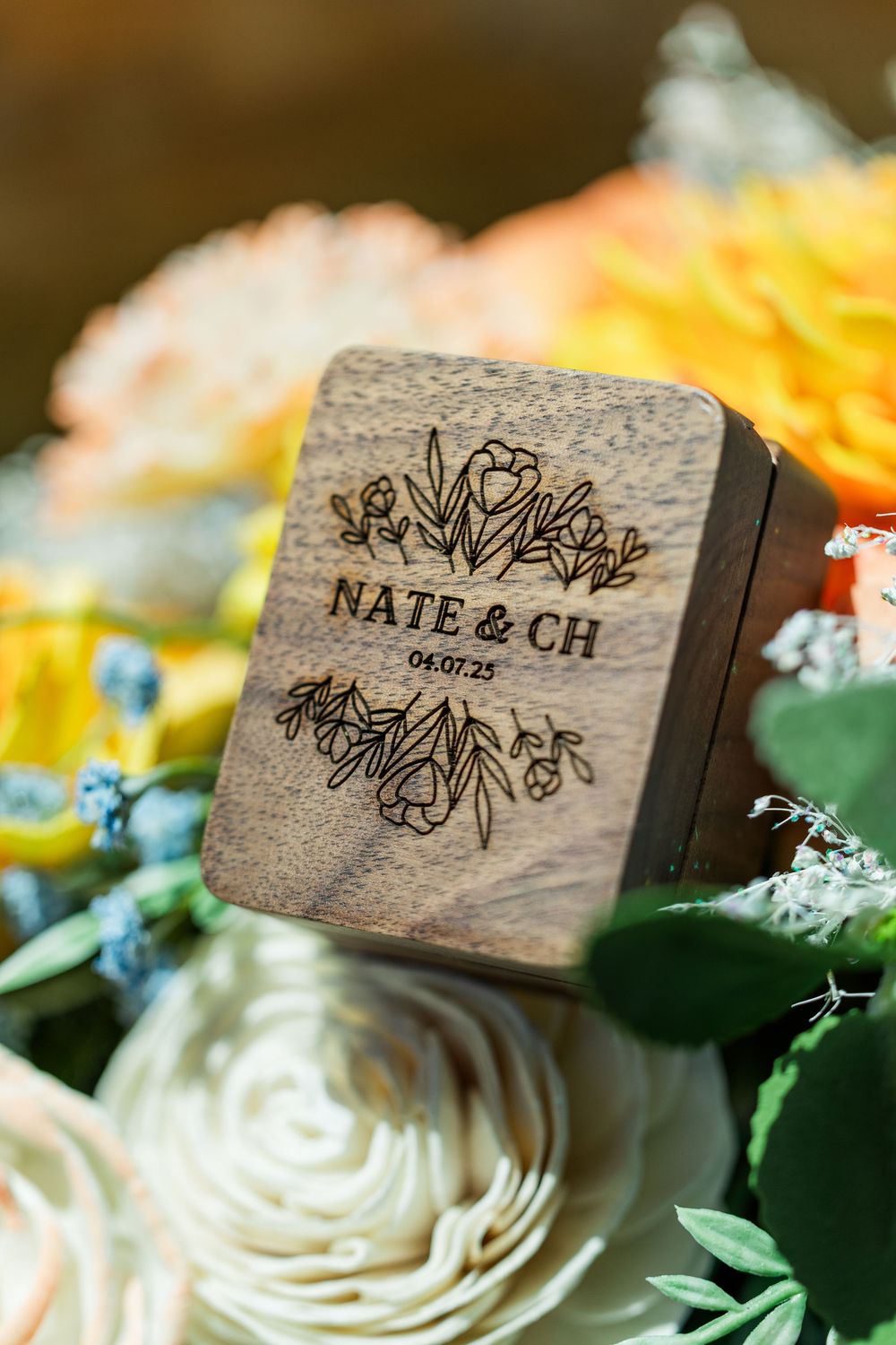 Wooden wedding favor box with floral design and couple's names engraved.