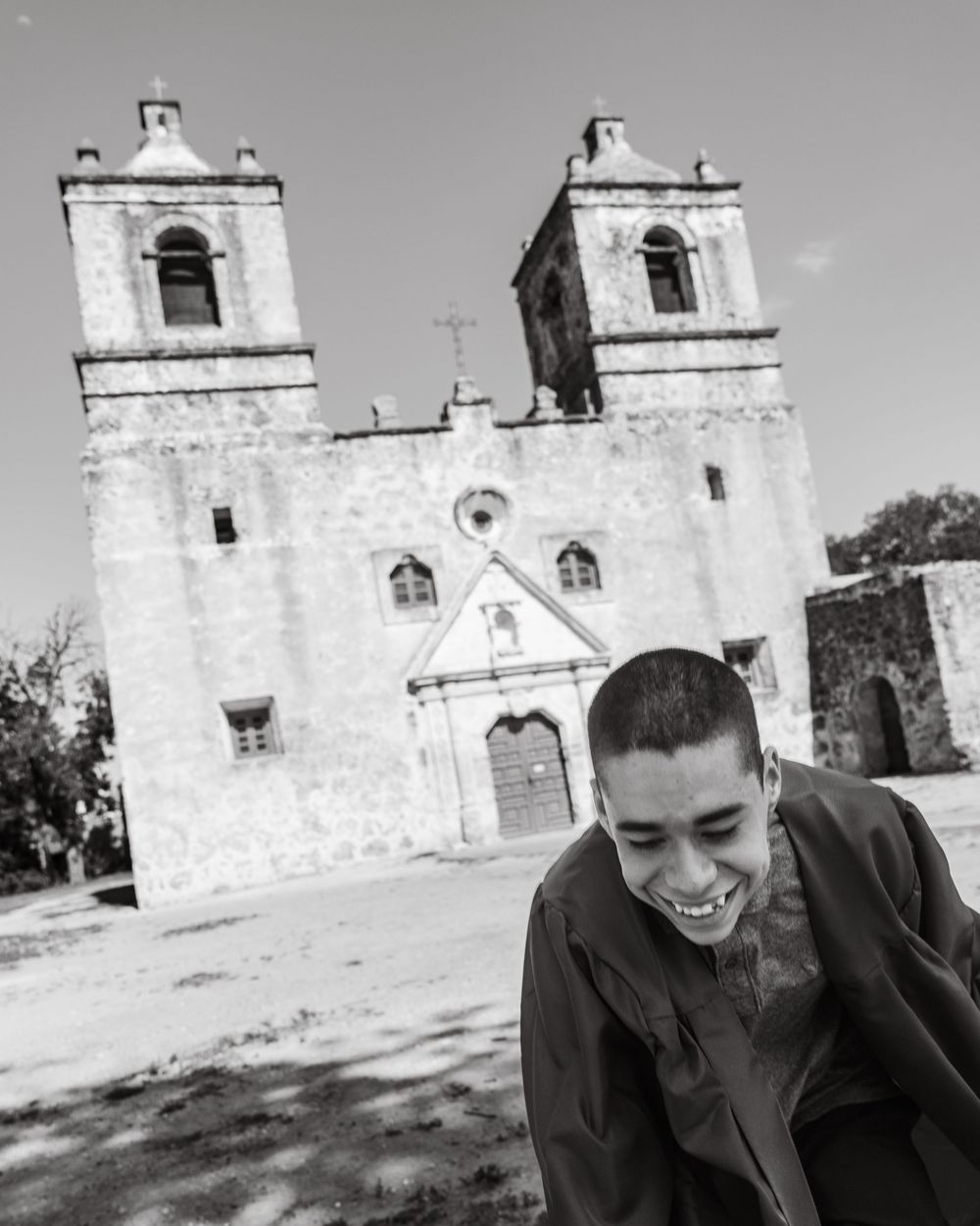 Black and white photo in front of historic mission church with twin bell towers.