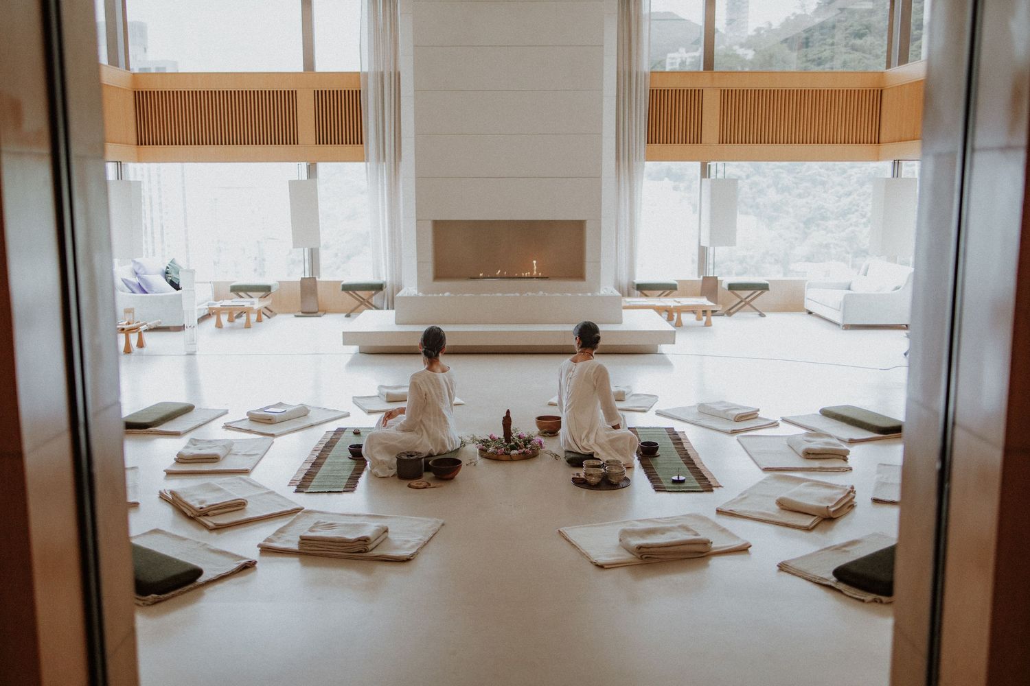 Wooden communal dining table with brown leather benches in a minimalist Japanese style restaurant interior.