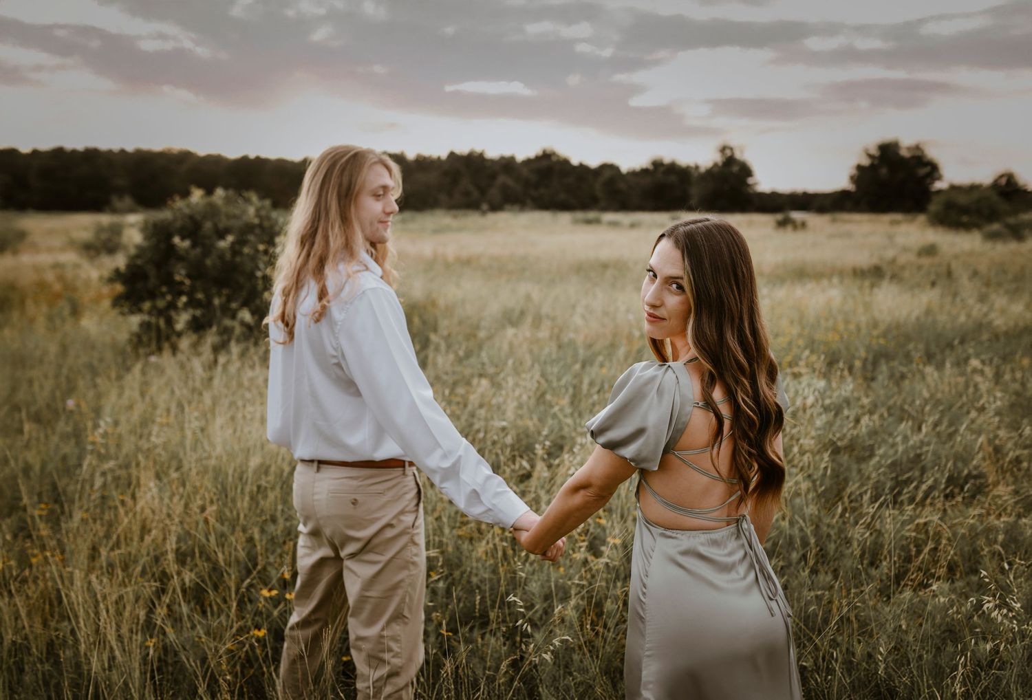 Romantic shot of couple framed by tall sunlit grasses