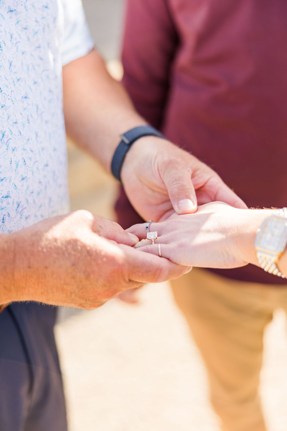 Close-up of hands placing an engagement ring during a romantic proposal moment.