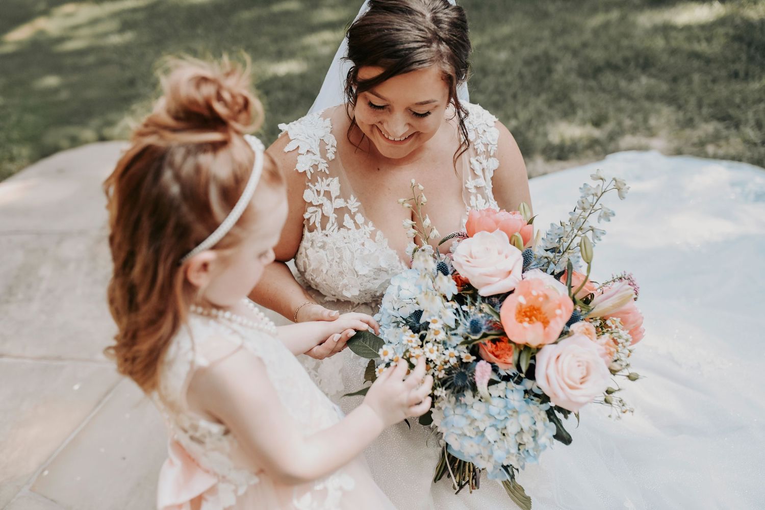 Bride holding her daughter’s hands while getting ready for the big day