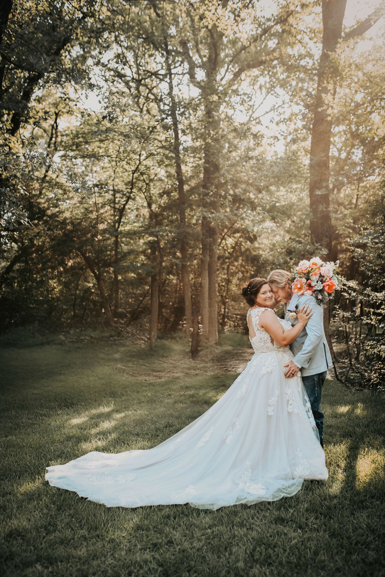 Bride and groom surrounded by pastel florals and fresh greenery