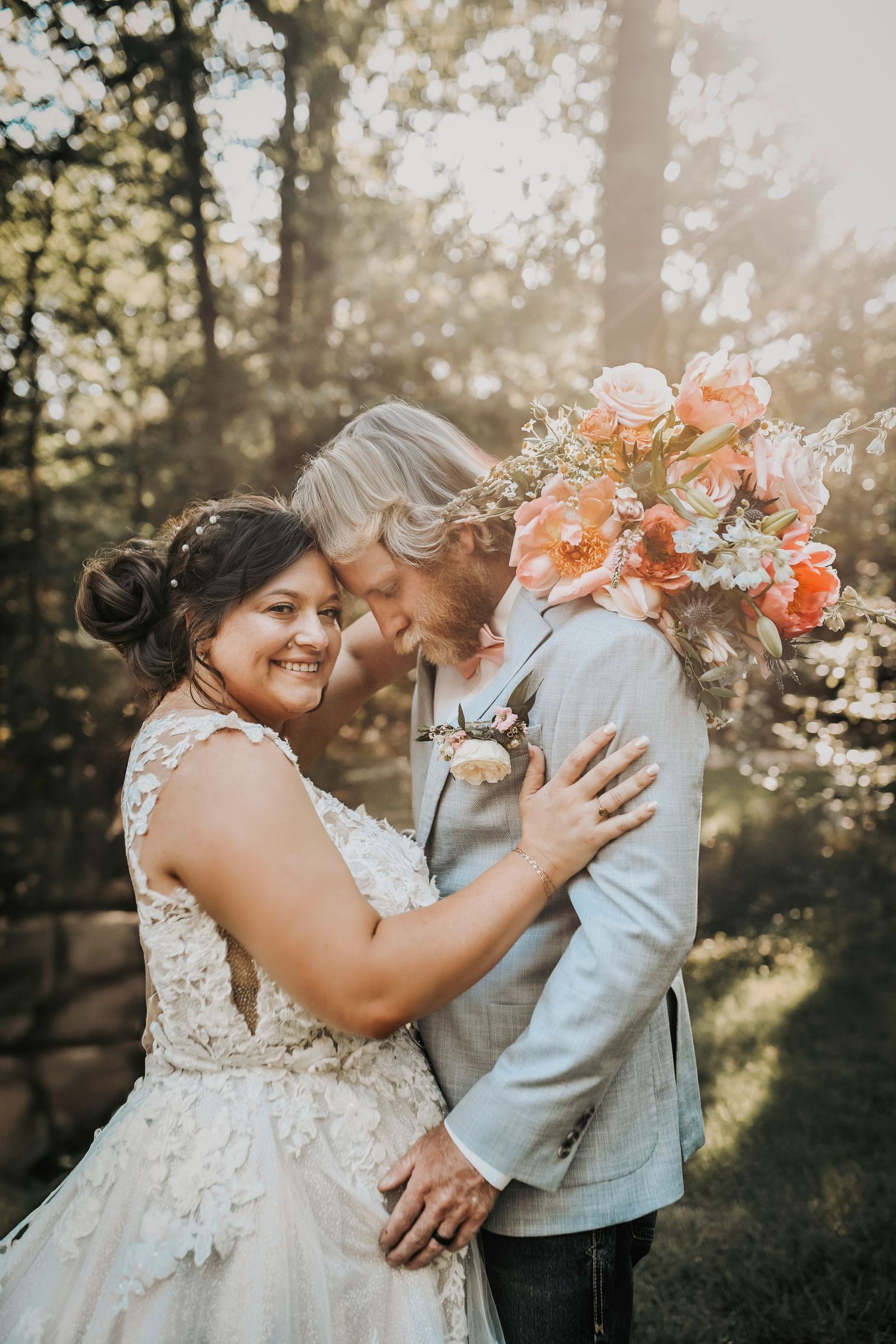 Woodland wedding vibes as bride and groom stand beneath towering oaks