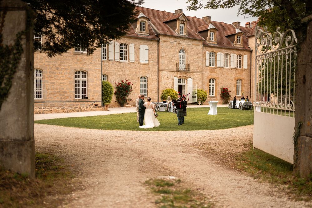 Les mariés devant le château pour le vin d’honneur sous un beau soleil.