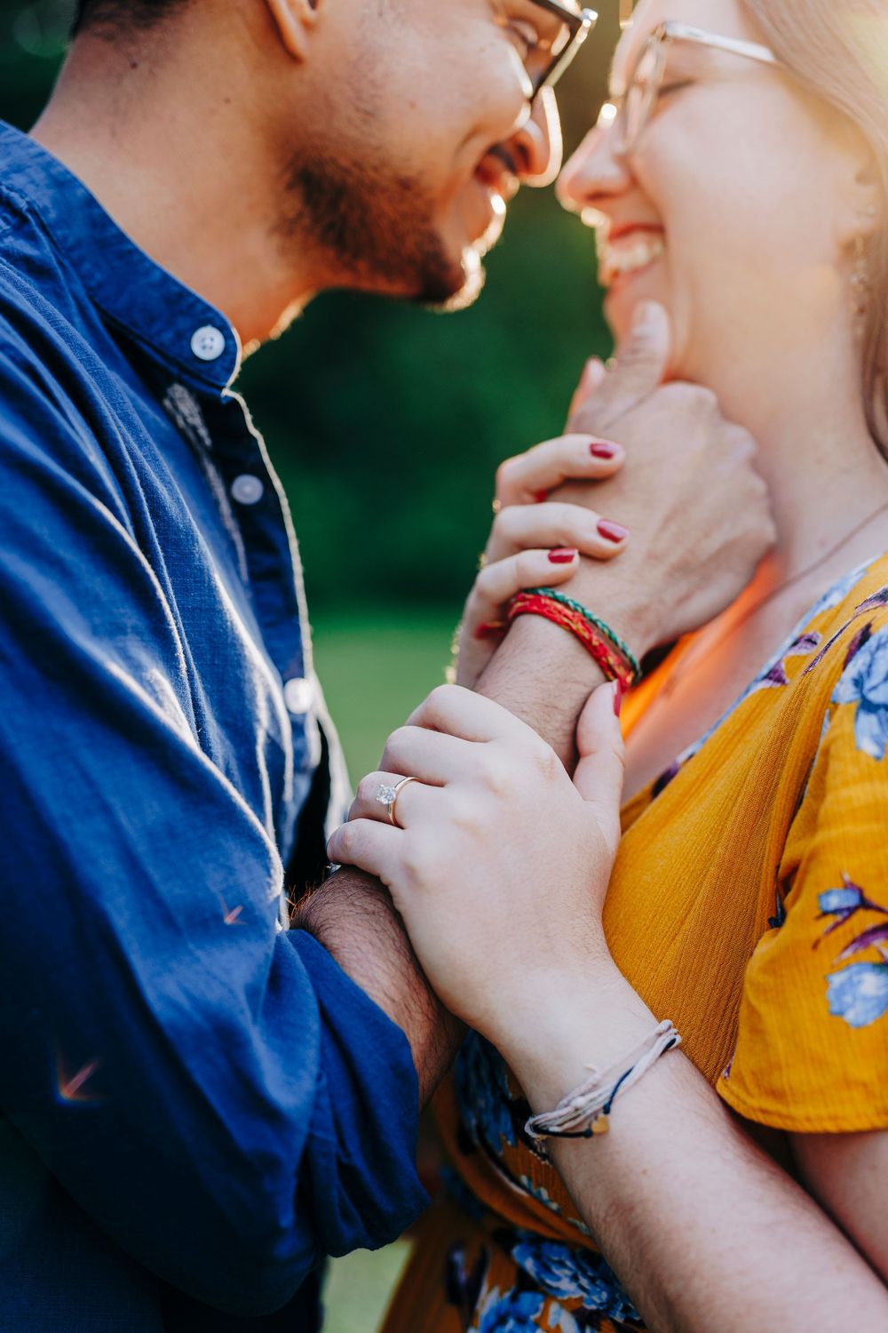 A couple embraces intimately wearing blue and yellow outfits in an outdoor setting.