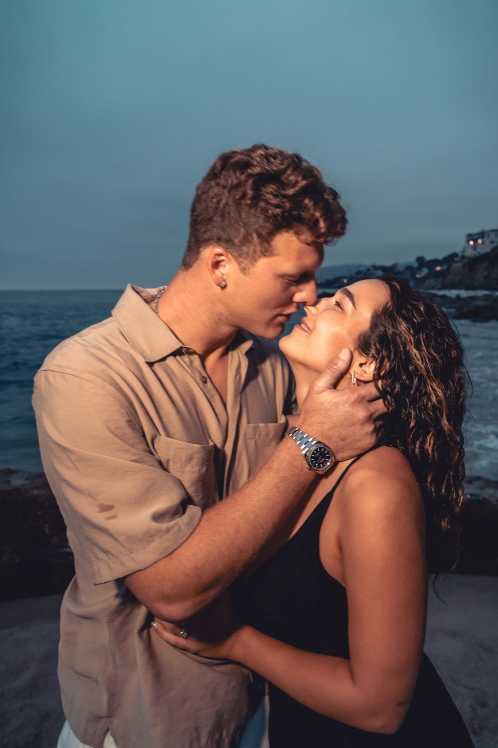 Romantic couple sharing intimate moments during sunset by the oceanside at dusk at victoria beach, laguan beach