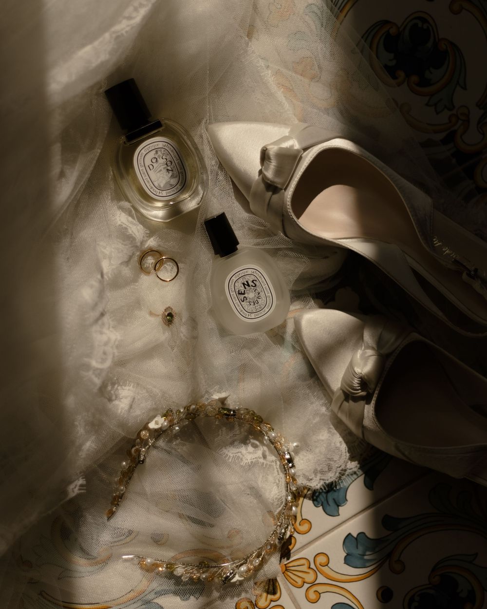 Atmospheric artistic still life of jewelry and misty smoke swirling around glowing glass objects on dark background.