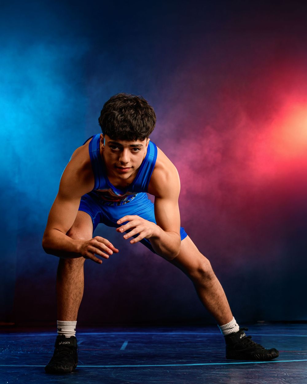 Arizona high school wrestler posing for media day portrait before Junior National Duals 2025, intense expression, smoke and lights