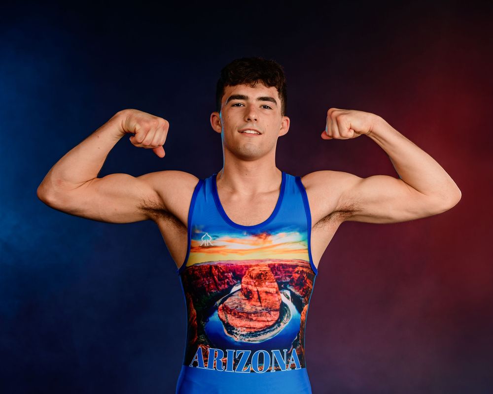 Arizona high school wrestler posing for media day portrait before Junior National Duals 2025, intense expression, smoke and lights