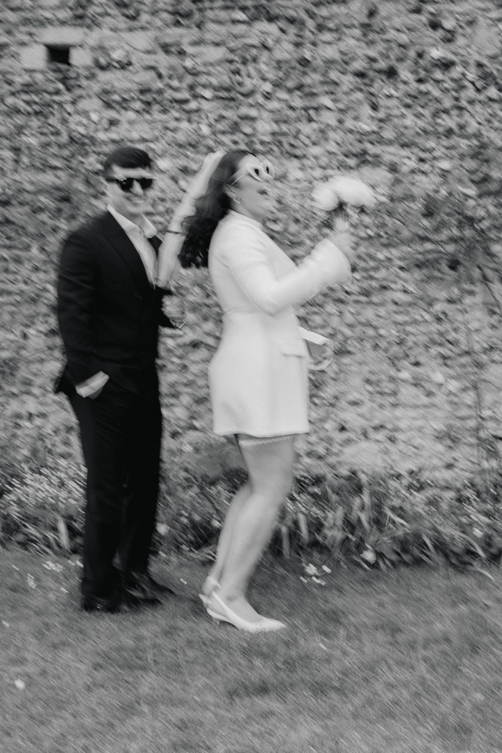 Grainy black and white photos capture two figures in dynamic movement against a rough textured wall.