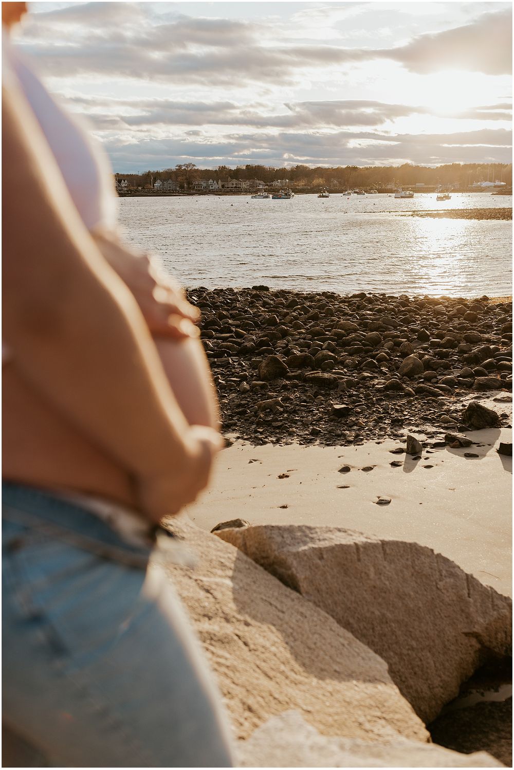Couple taking maternity photos at the beach in New Hampshire
