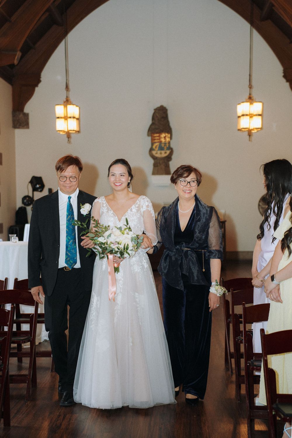 Wedding party members gather inside wood-beamed church sanctuary.