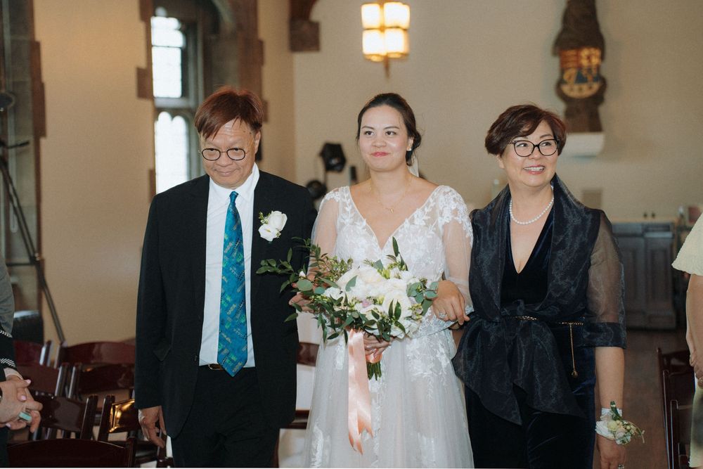 Wedding party members stand together inside traditional church interior.
