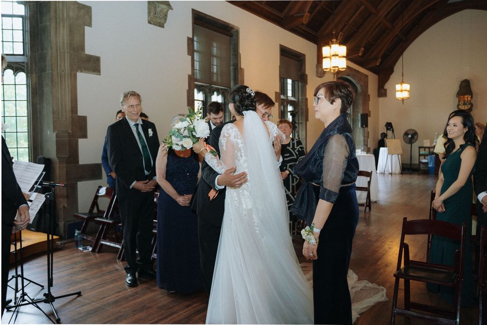Wedding ceremony held in rustic church hall with wooden beams and stained glass windows.