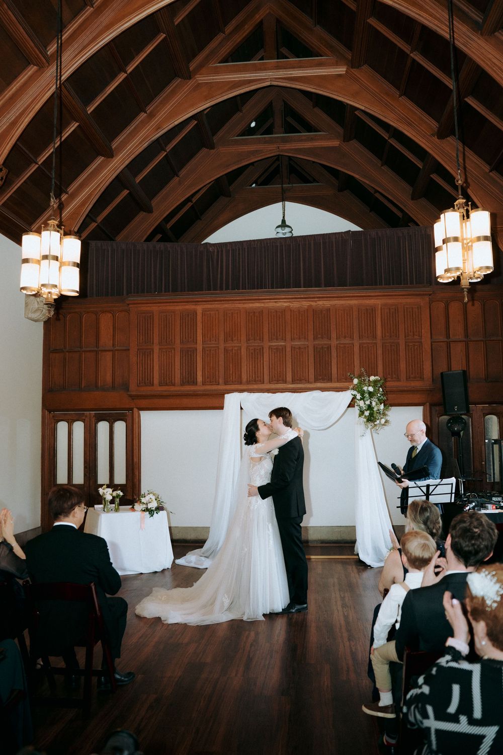 Series of ceremony photos showing arched wooden ceiling and pendant lighting in historic venue.
