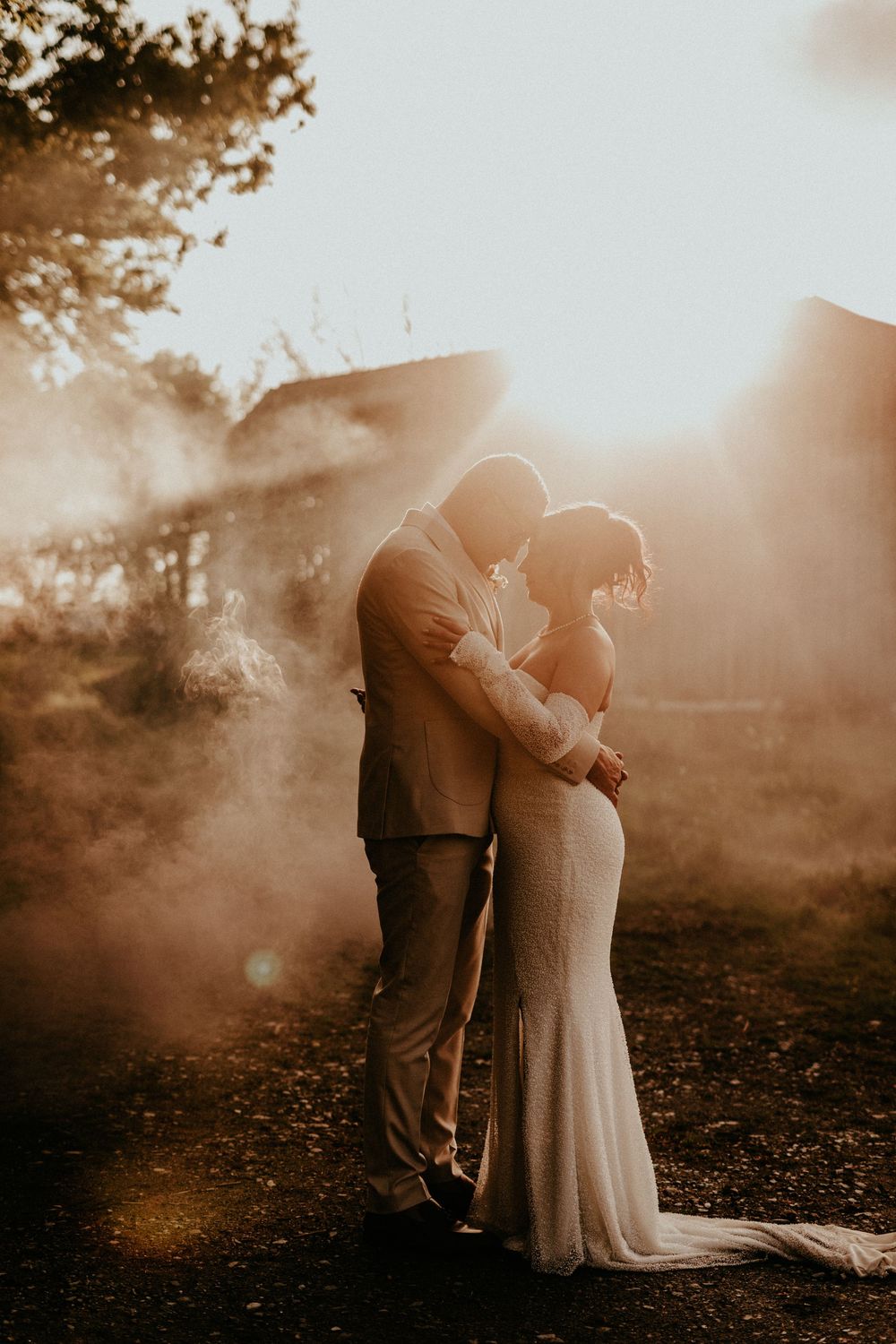 A romantic silhouette of a couple embracing in a dreamy, sun-drenched landscape with hazy golden light.