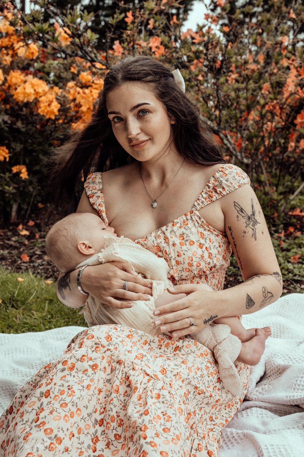 Mother breastfeeding baby in flower garden