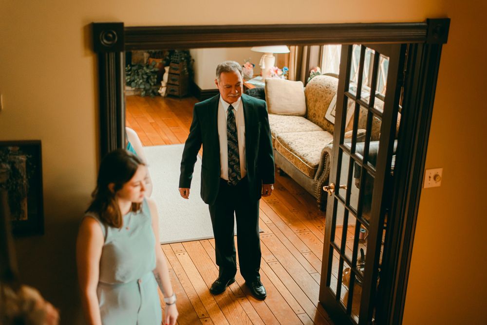 Dad in living room watching bride on stairs