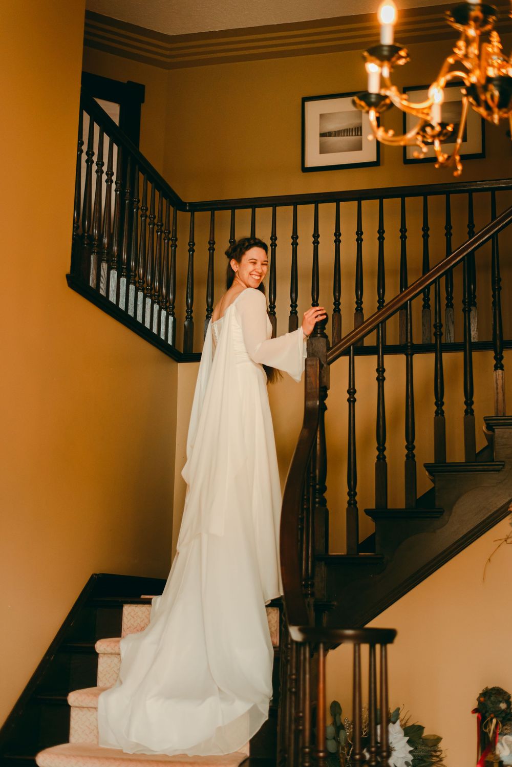 Bride walking up grand staircase showing off fairytale inspired wedding dress