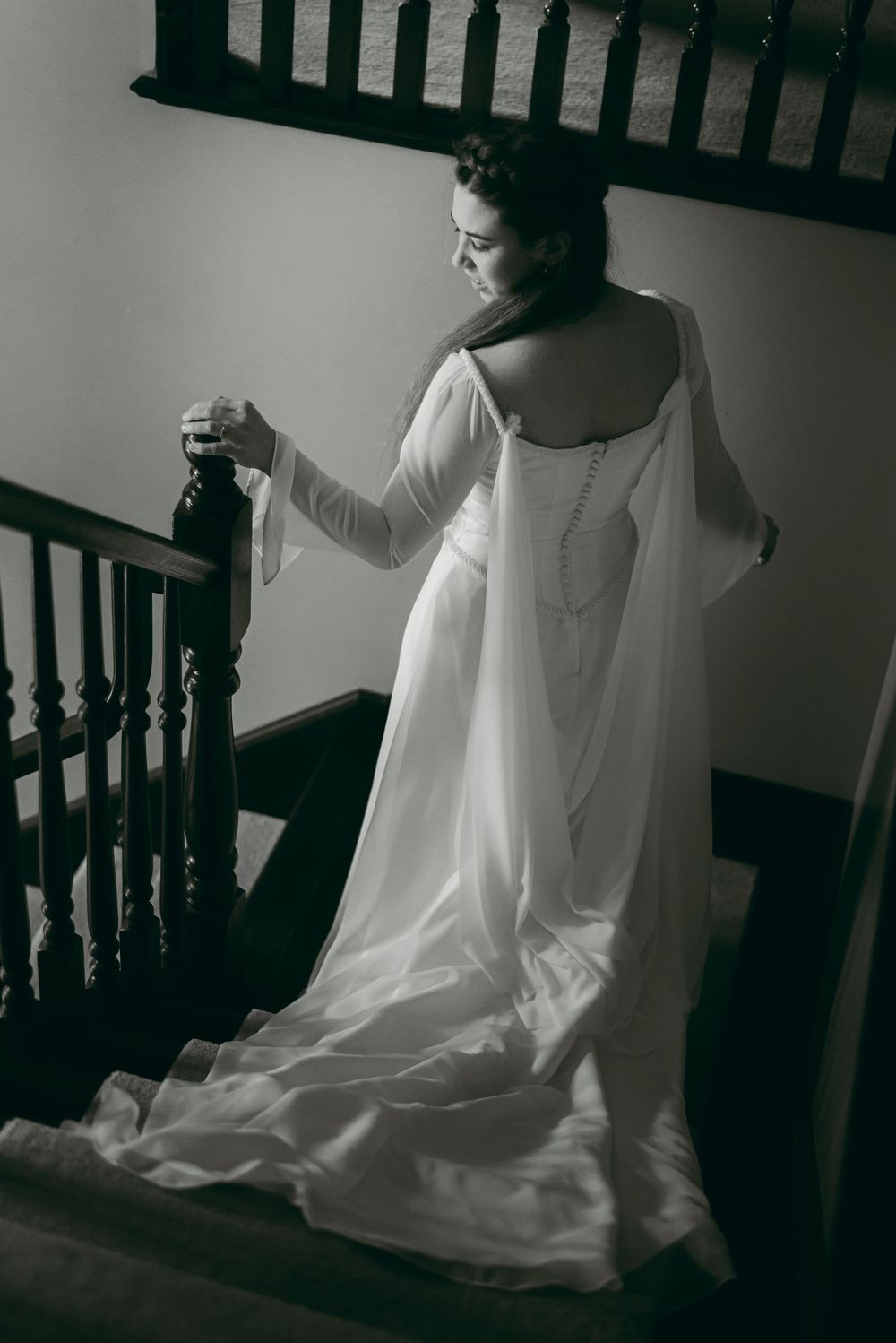 Bride walking down grand staircase showing off fairytale inspired wedding dress