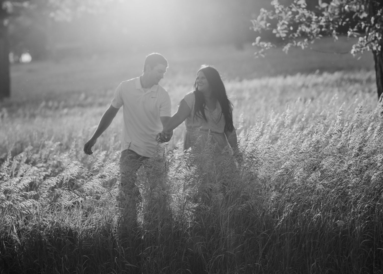 Husband + wife sharing a romantic moment in a field at sunset in Iowa, captured during an outdoor photo session by professional photographer