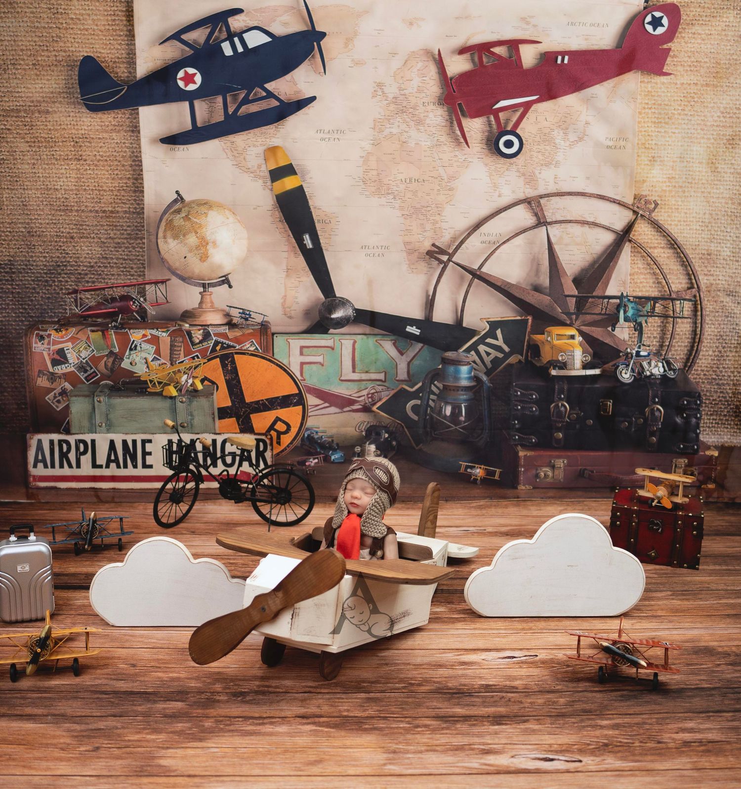 Vintage aviation themed still life with toy planes, clouds and antique decor items on wooden background.