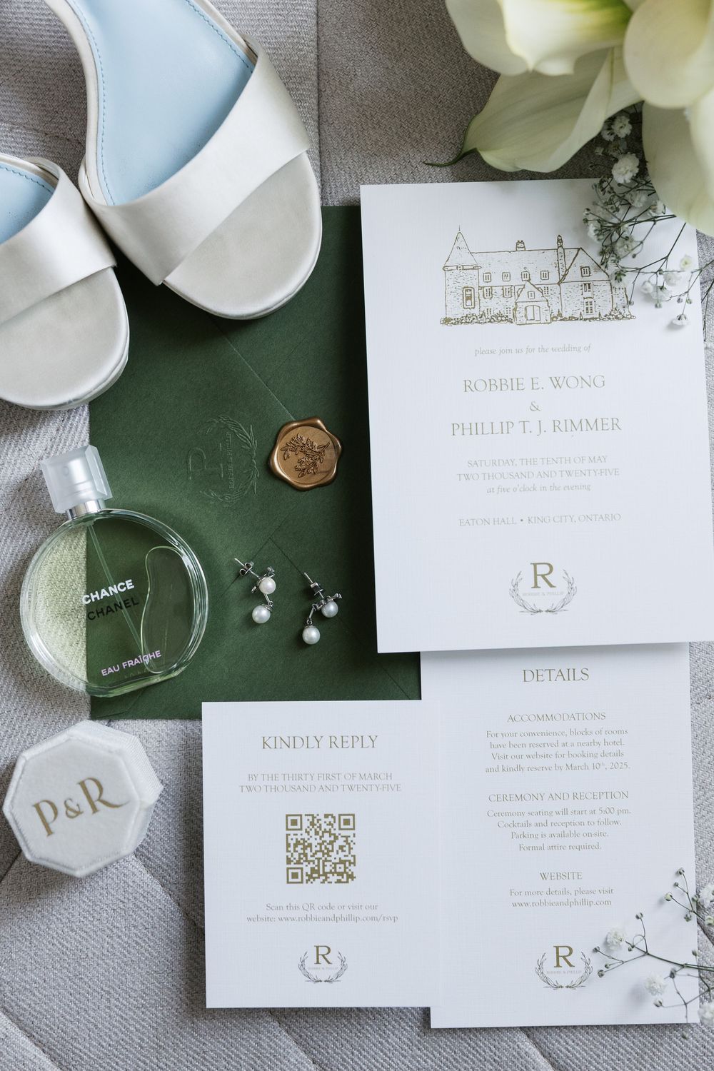 Wedding invitation with a custom venue illustration alongside bridal shoes, perfume, and elegant details.