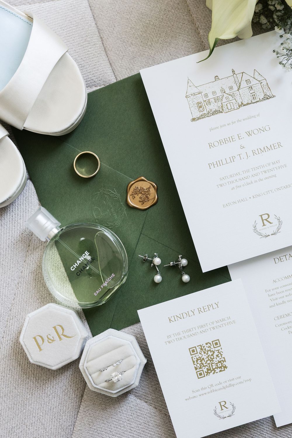 Wedding invitation suite with venue illustration, rings, and accessories on green and white background.