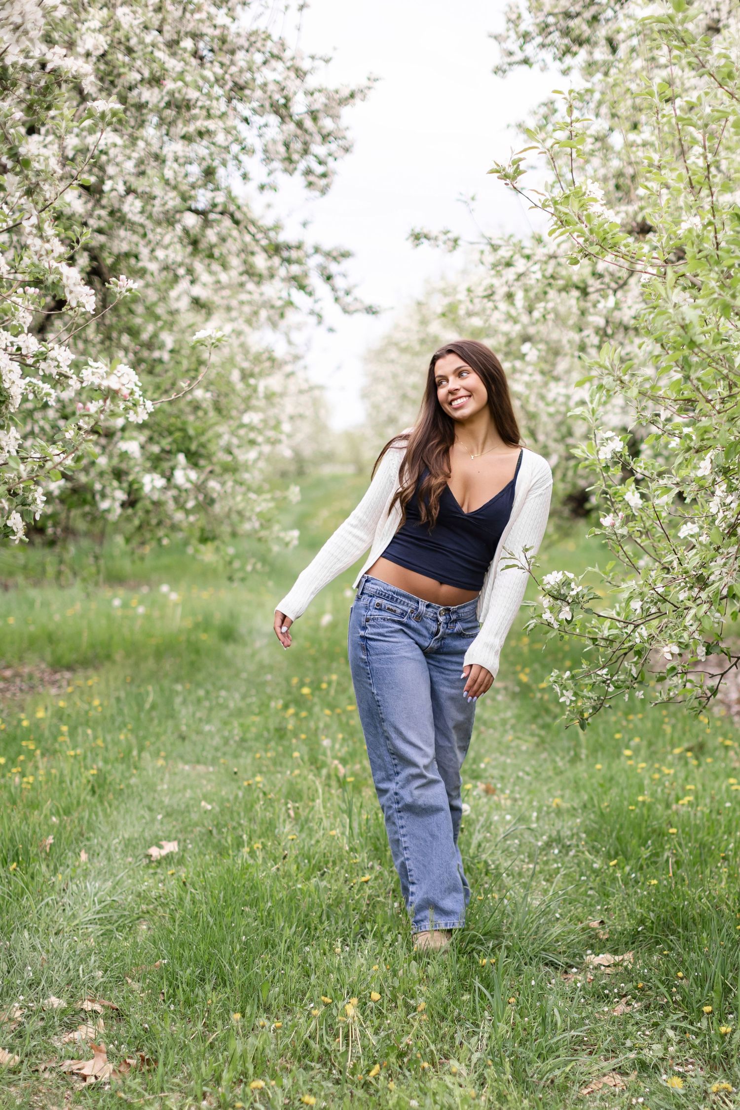 Senior portrait in front of apple trees in full bloom near Kalamazoo County, Michigan