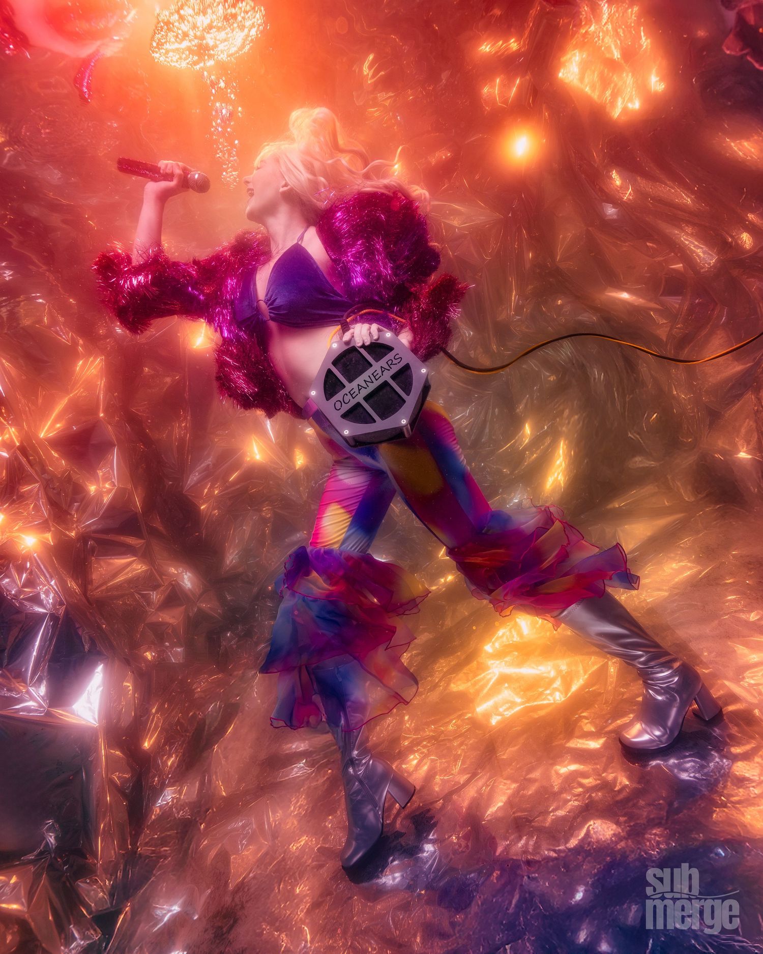 A performer in a space suit strikes a dramatic pose against a cosmic background with vibrant red and purple lighting effects.