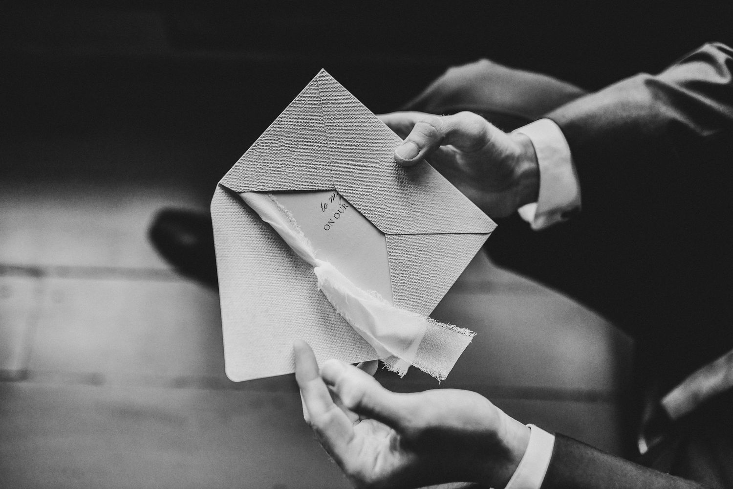the groom opens his love letter from the bride on his wedding day